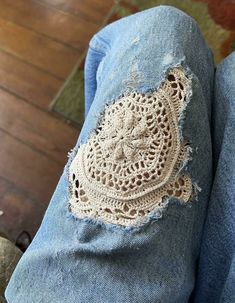 someone is wearing jeans with crochet on them