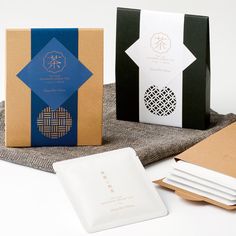 three different boxes are sitting next to each other on a cloth with paper napkins