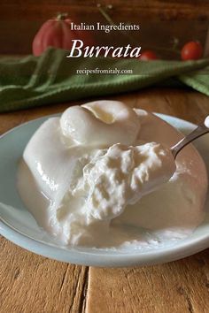 a white plate topped with whipped cream on top of a wooden table