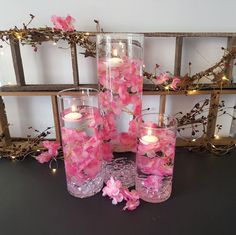 pink flowers in glass vases with lit candles