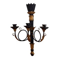 an ornate black and gold candelabra with four candles