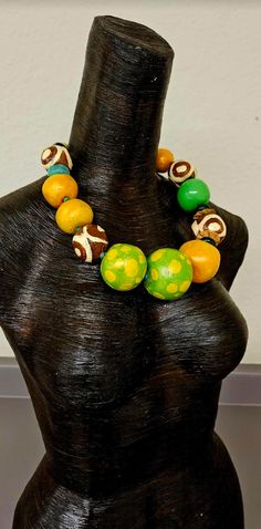 Even though this is a new listing, I am placing it in the FINAL SALE collection since I am not entirely pleased with the way the paint behaved on this piece. Large and oversized hand sculpted beads are painted in a variety of colors: orange with a color shift glaze, green and yellow polka dot with a color shift glaze, lime green, African batik patterned beads, agate, coconut, resin and African glass. Most beads are separated with tiny turquoise spacers. The sculpted beads are sealed with a satin Unique Wooden Beaded Necklaces, Green Wooden Beads Necklaces For Festivals, Artistic Green Necklace For Festivals, Unique Green Wooden Beads, Unique Green Necklaces With Wooden Beads, Green Wooden Beaded Necklaces, Unique Green Wooden Beaded Necklaces, Rocker Chic Accessories, Unique Pendant Necklace