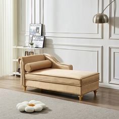 a chaise lounge chair sitting on top of a wooden floor next to a white rug