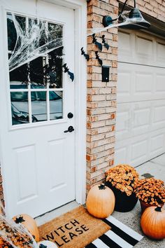 two pumpkins sitting in front of a white door with the words witch please on it