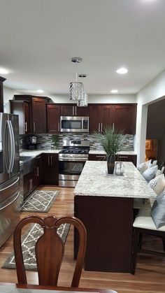 a large kitchen with stainless steel appliances and wooden flooring is pictured in this image