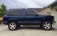 a blue suv parked in front of a house