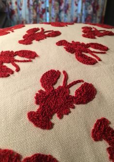 a crocheted red and white bedspread with flowers on it