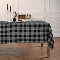 a black and white checkered tablecloth on a wooden table next to two candles