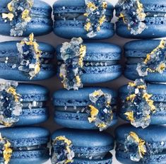 blue macaroni shells with yellow and white decorations on them are arranged in a pattern