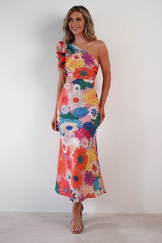 a woman in a colorful dress posing for the camera