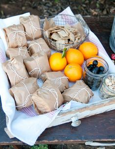 an assortment of fruits and nuts on a table with some paper bags wrapped around them