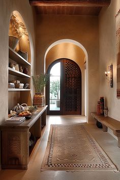 a hallway with an archway leading to the kitchen and dining area, along with a rug on the floor