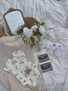 the contents of a diaper laid out on a bed with flowers and baby shoes