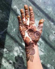 a woman's hand with henna tattoos on it