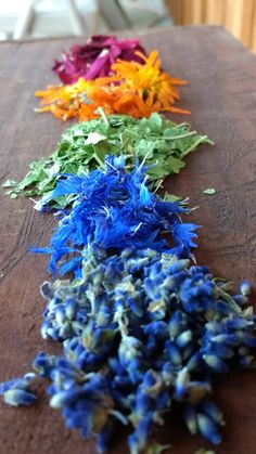 several different colored flowers on a wooden table