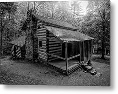 black and white photograph of an old log cabin in the woods