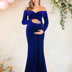 a pregnant woman in a blue gown posing for the camera