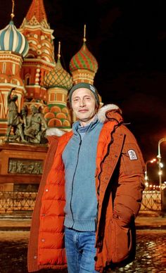 a man standing in front of a building with domes on it's sides at night