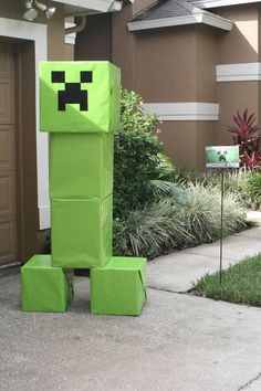 a green creeper statue sitting in front of a house