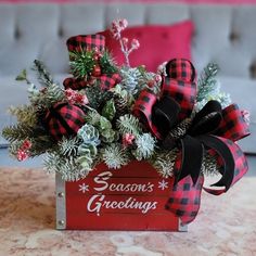 a christmas arrangement in a red box on a table