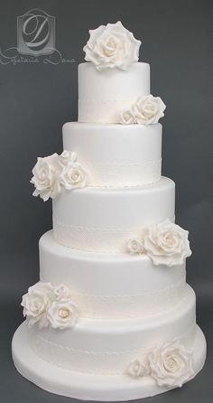 a three tiered white wedding cake with flowers