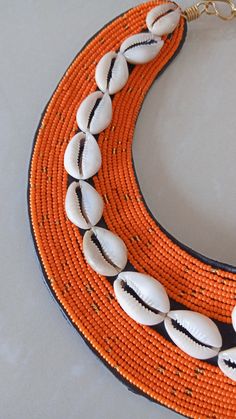 African beaded cowrie shell necklace, African ceremonial necklace, Wedding necklace, beaded necklace, Christmas gift for her This cowrie shell beaded necklace is superbly crafted which can be worn with any outfit at different occasions and it will absolutely makes you stand out. Main color -Orange. The necklace can be available in different colors. Wholesale available at a fair price,please contact me. For any clarification,please send me a convo or an e-mail. Thank you for visiting and happy sh Traditional Orange Necklace For The Beach, Traditional Cowrie Shell Beaded Necklaces For Beach, Traditional Beaded Shell Necklace For Festival, Traditional Orange Beaded Necklaces For Beach, Handmade Cowrie Shell Beaded Necklaces For Festivals, Beaded Cowrie Shell-shaped Jewelry, Handmade Shell-shaped Beaded Necklace For Festival, Beaded Cowrie Shell Necklace, Beaded Cowrie Shell Jewelry