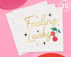 three napkins with the words feeling lucky on them and two cherries in gold foil