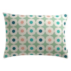 a green pillow with blue, pink and orange dots on it's back side