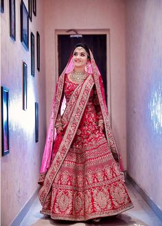 a woman in a red and gold bridal gown is walking down the hallway to her wedding