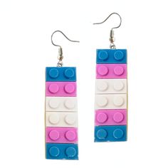 the earrings are made out of legos and have pink, blue, and white blocks