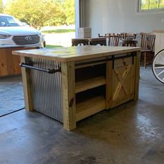 a kitchen island made out of metal and wood with wheels on the floor next to it