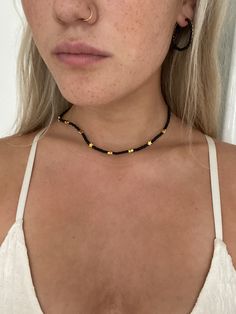 a sophisticated  and elegant  black seed bead choker with gold stars finished with lobster clasp. Chokers are making a major come back so this little black beauty needs to be a part of everyone's wardrobe.gold stars are made from quality alloy material, durable and not easy to fade. gift for her. boho gift . stunning worn with other necklaces to give that edgy look.  . christmas gift. homemade with love and care. choker approx 17 inches in length.. if you need the choker made to any particular length. please message me .. ❤️   Care instructions  ✨in order for your jewellery to stay in perfect condition, it is advised to keep items out of contact with any harsh chemicals,creams,perfumes and water. ✨it is best to store your jewellery in a dark dry place,such as a jewellery box when it's not Trendy Gold Choker With Tiny Beads, Minimalist Gold Necklace With Black Beads, Black Beaded Choker Necklace, Black Beaded Necklaces With Gold Beads For Festival, Trendy Black Beaded Choker Necklace, Minimalist Gold Beaded Necklace With Black Beads, Black Necklaces With Gold Beads For Festival, Black Tiny Beads Choker Necklace, Casual Black Beaded Choker Necklace