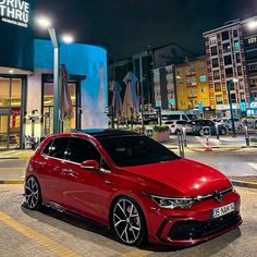 a red car parked in front of a building