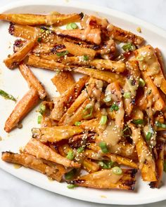 a white plate topped with french fries covered in sauce