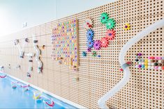 there is a wall that has many different colored beads on it and a white pipe in the middle