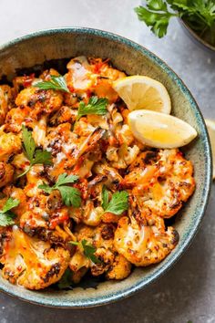 a bowl filled with cooked cauliflower and garnished with parsley