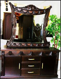 an ornate wooden dresser with a large mirror on it's top and bottom shelf