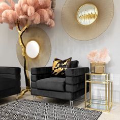 a living room with black couches, gold accents and pink flowers on the wall