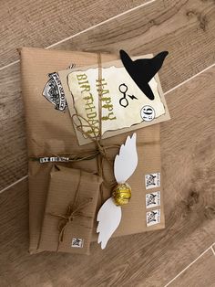 a package wrapped in brown paper on top of a wooden floor with tags and decorations