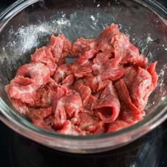 raw meat in a glass bowl on top of a stove