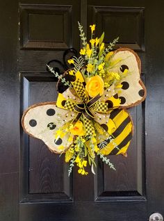 a yellow and black butterfly door hanger with flowers on it's front door