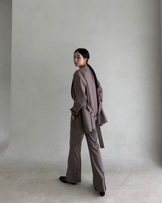 a woman standing in front of a white wall