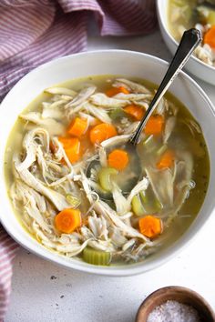 two bowls of chicken noodle soup with carrots and celery