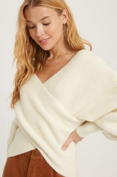 Stay cozy and chic with our Ivory Ribbed Off-the-Shoulder Sweater. Featuring a unique crossover neckline and trendy balloon sleeves, this relaxed-fitness sweater will keep you both stylish and comfortable. Perfect for layering or wearing on its own, this sweater is a versatile addition to any wardrobe! -77% Acrylic 20% Nylon 3% Spandex Fit True to size Sarah is wearing S/M S/M-4 to 8 M/L- 10 to 14