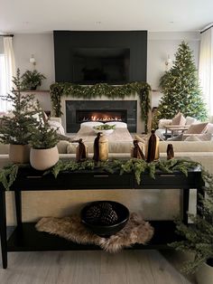 a living room filled with furniture and a fire place covered in christmas greenery next to a fireplace