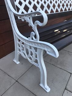 a white bench sitting on top of a sidewalk