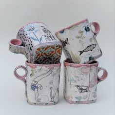 four mugs are stacked on top of each other with different designs and colors in them