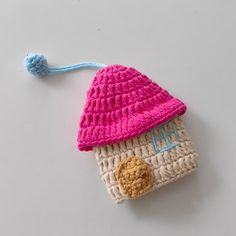 a crocheted hat with a button on the side and a pom - pom attached to it