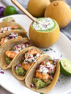 shrimp tacos with guacamole and limes on the side