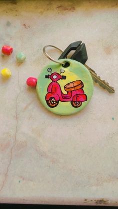 a pink scooter keychain sitting on top of a table next to candy